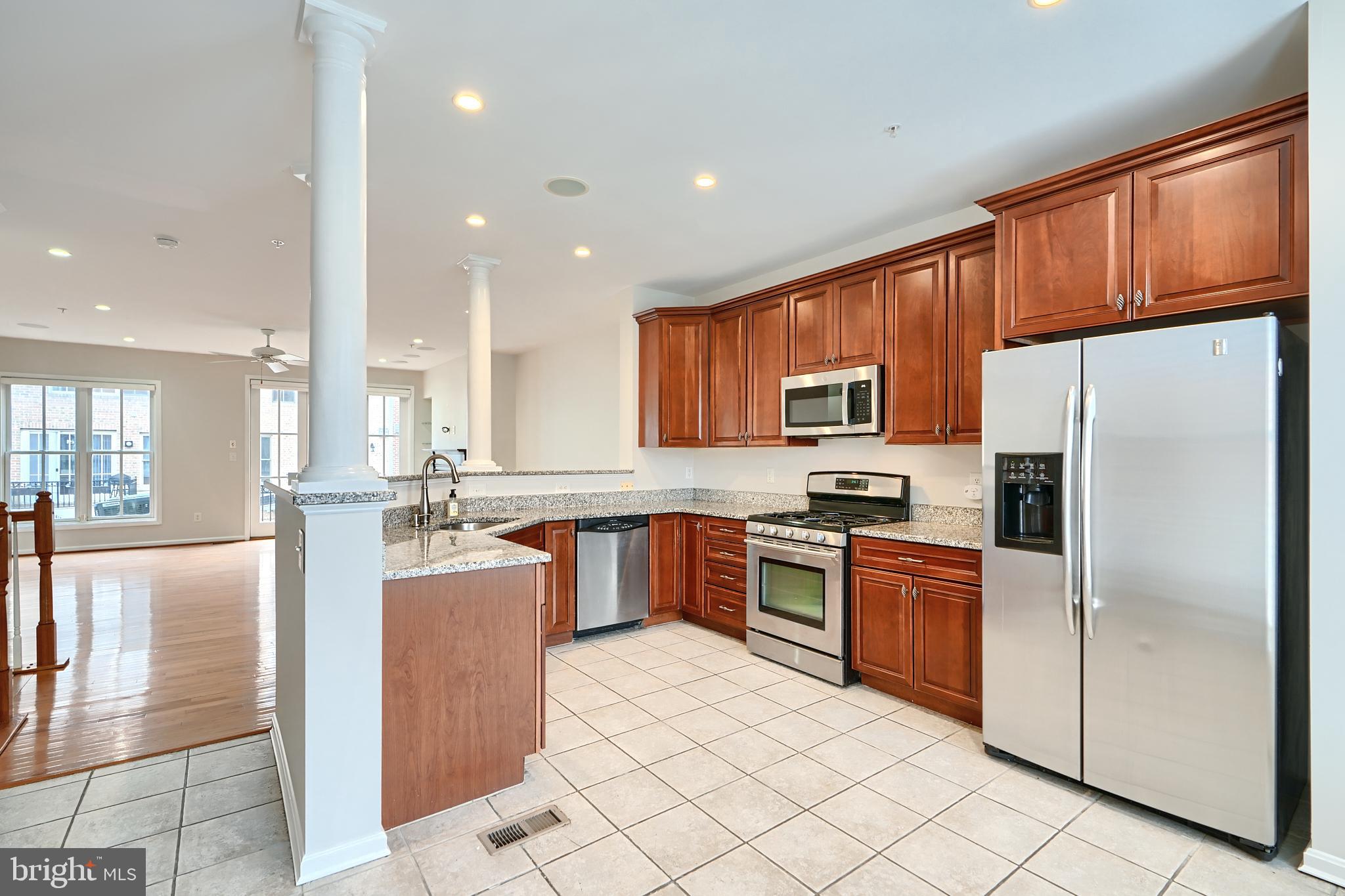 1205 Dockside Circle Baltimore, MD 21224 - Photo 18 of 39 a kitchen with stainless steel appliances granite countertop a refrigerator a stove a sink a oven with a dining table and chairs