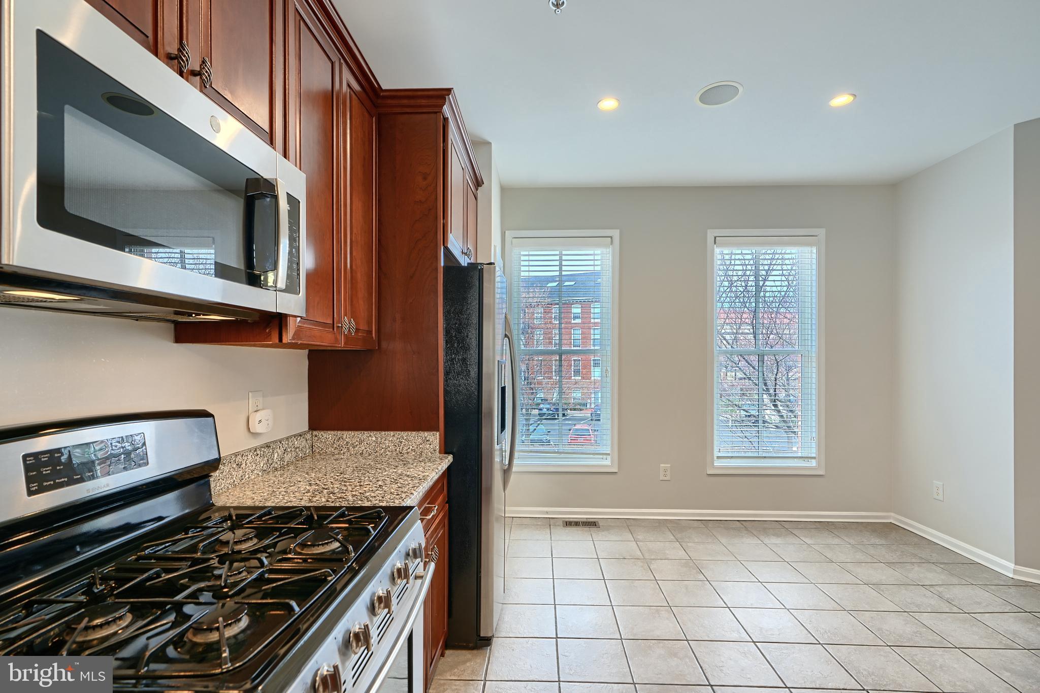 1205 Dockside Circle Baltimore, MD 21224 - Photo 20 of 39 a kitchen with stainless steel appliances granite countertop a stove and a microwave