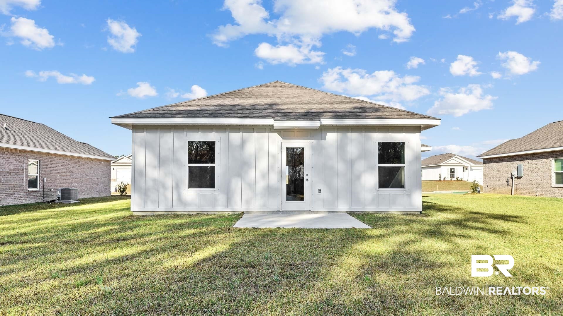 13356 Shea Circle Foley, AL 36535 - Photo 12 of 15 Rear exterior featuring board and batten siding, a gabled roof, and a concrete patio