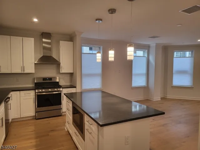 a kitchen with stainless steel appliances granite countertop a sink and a stove