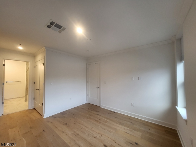 18 Ward Street Bloomfield, NJ 07003 - Photo 10 of 20 an empty room with wooden floor and windows