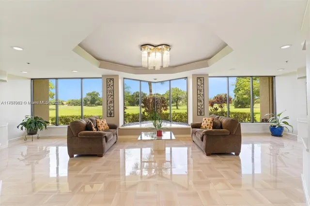 a living room with furniture and floor to ceiling windows
