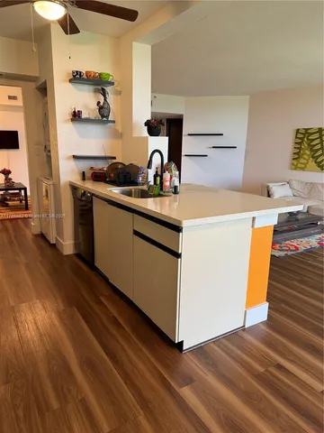 a kitchen with a sink and wooden floor