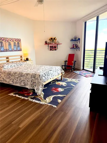 a bedroom with bed and wooden floor