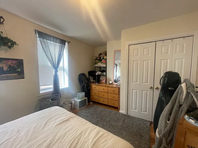 a bedroom with a bed and a large window