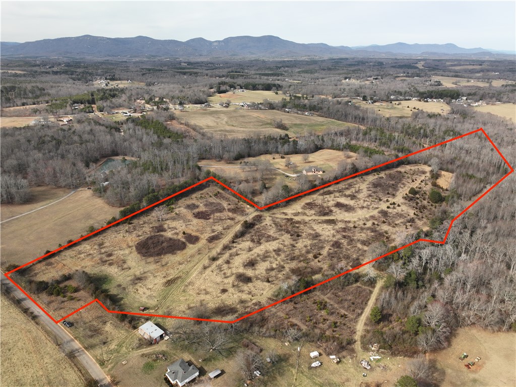 Expansive acreage offering a blend of cleared land and mature trees, ideal for diverse development.