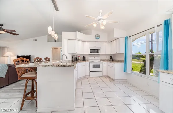 a kitchen with cabinets and chairs
