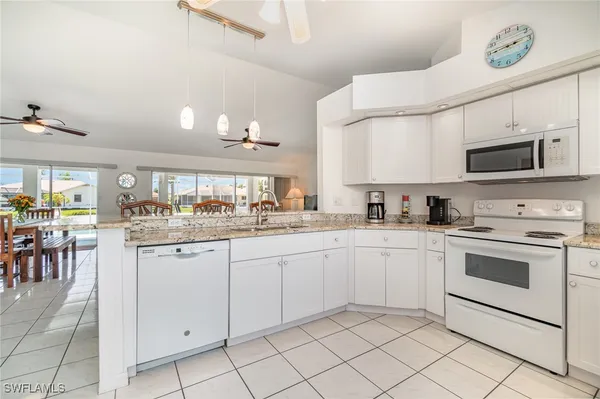 a kitchen with granite countertop appliances cabinets and a sink