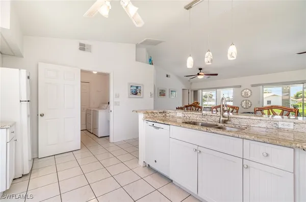 a room with white cabinets and chandelier