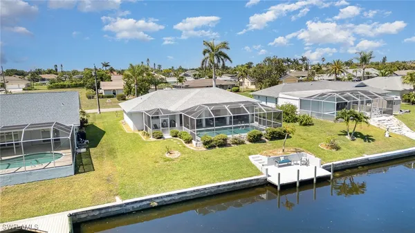 an aerial view of a house with swimming pool and large trees