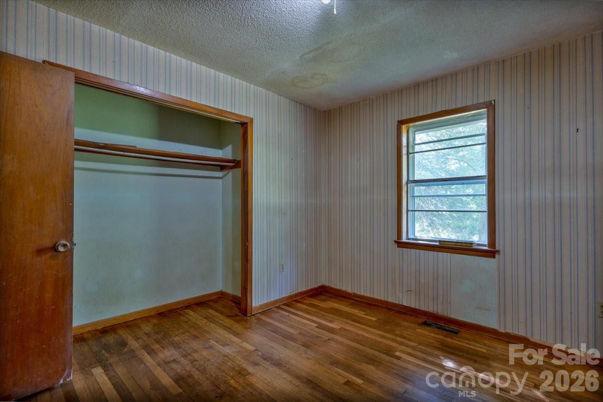 156 Old Sweetwater Road Robbinsville, NC 28771 - Photo 16 of 25 an empty room with wooden floor closet and windows