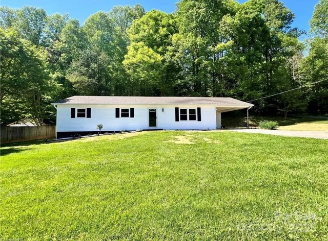 a aerial view of a house with swimming pool next to a yard
