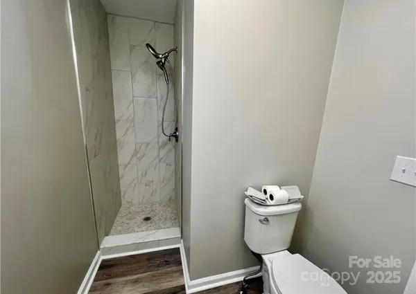 a bathroom with a granite countertop toilet a sink and shower