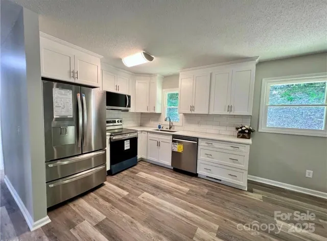 a kitchen with granite countertop a refrigerator stove and oven