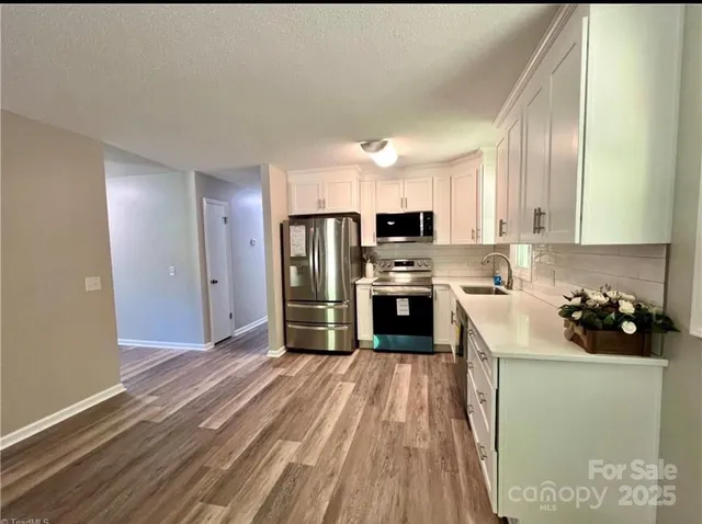 a kitchen with a refrigerator sink and wooden floor