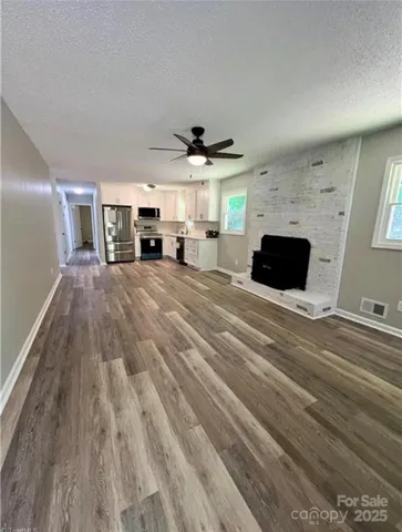 a large room with chandelier flat screen tv and windows