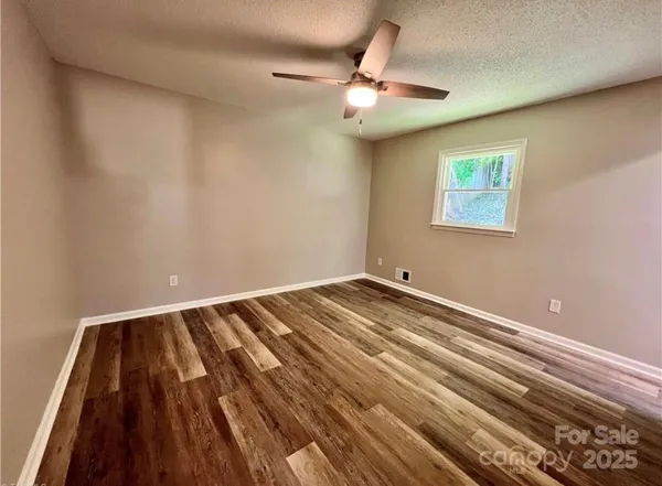 a view of a room with wooden floor and fan
