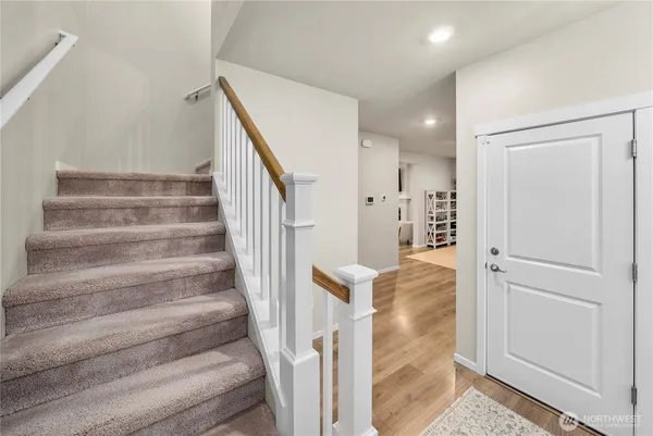 a view of entryway and hall with wooden floor