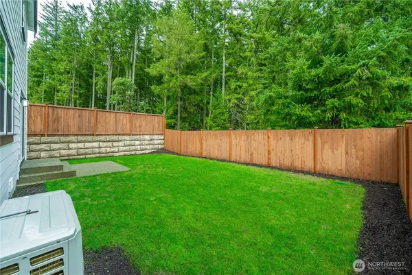 a view of a backyard with a small cabin and wooden fence