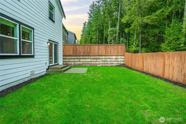 a view of a backyard with a small cabin and wooden fence