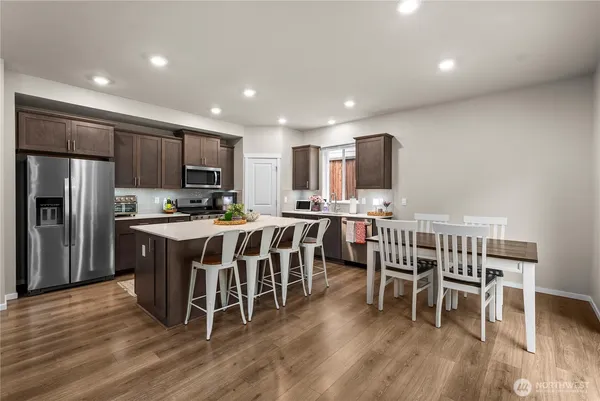 a kitchen with stainless steel appliances wooden floors and wooden cabinets