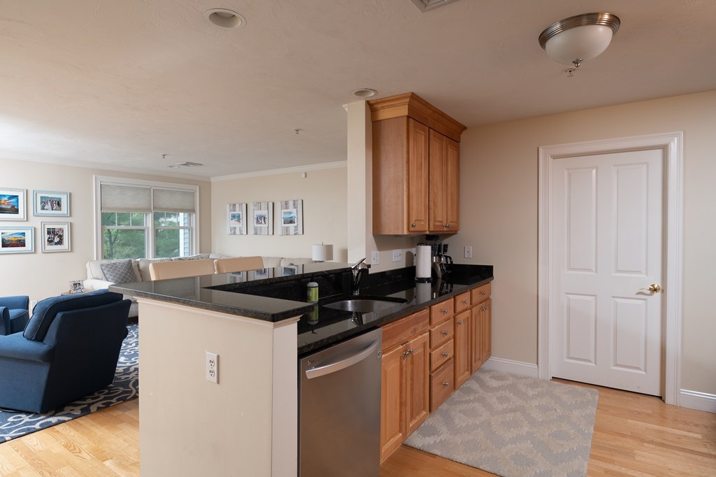 29 Maple Street, Unit E Canton, MA 02021 - Photo 6 of 23 a kitchen with granite countertop a sink and cabinets