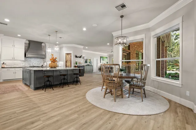 a kitchen with stainless steel appliances granite countertop a kitchen island a stove and a wooden floors