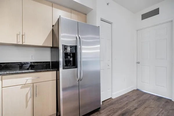 a kitchen with stainless steel appliances granite countertop a refrigerator and a stove top oven