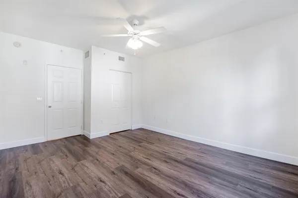 a view of an empty room with wooden floor