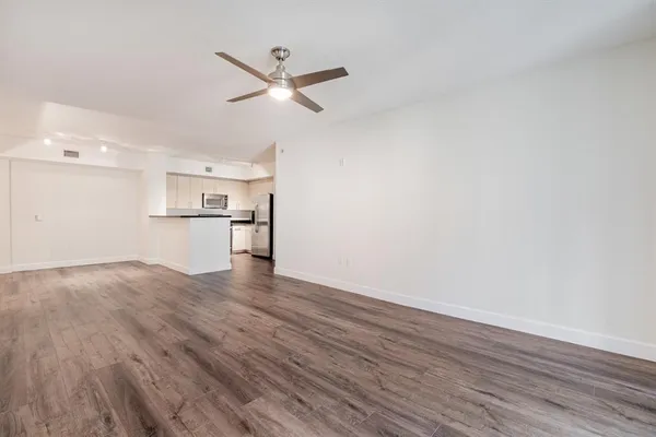 a view of empty room with wooden floor and window