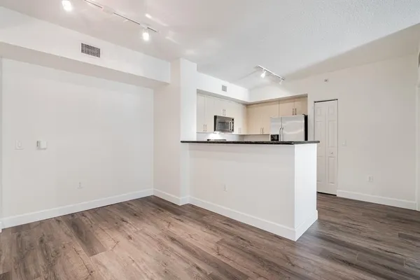 a view of a kitchen with wooden floor and a sink