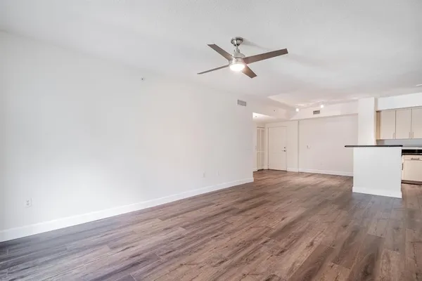 a view of a room with wooden floor and a ceiling fan