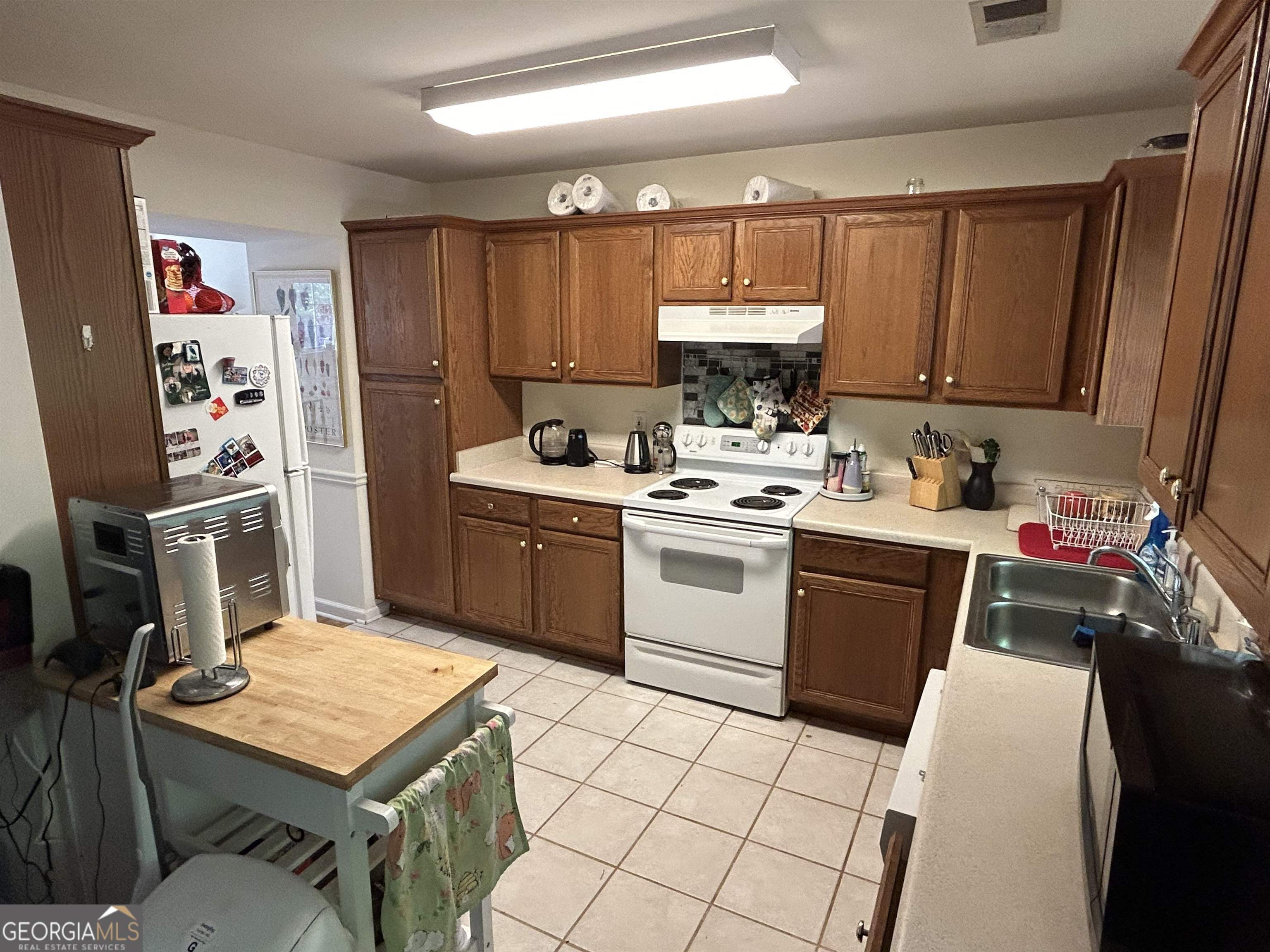 174 Spring Lake Drive Athens, GA 30605 - Photo 5 of 10 a kitchen with a sink a stove a refrigerator cabinets and a window