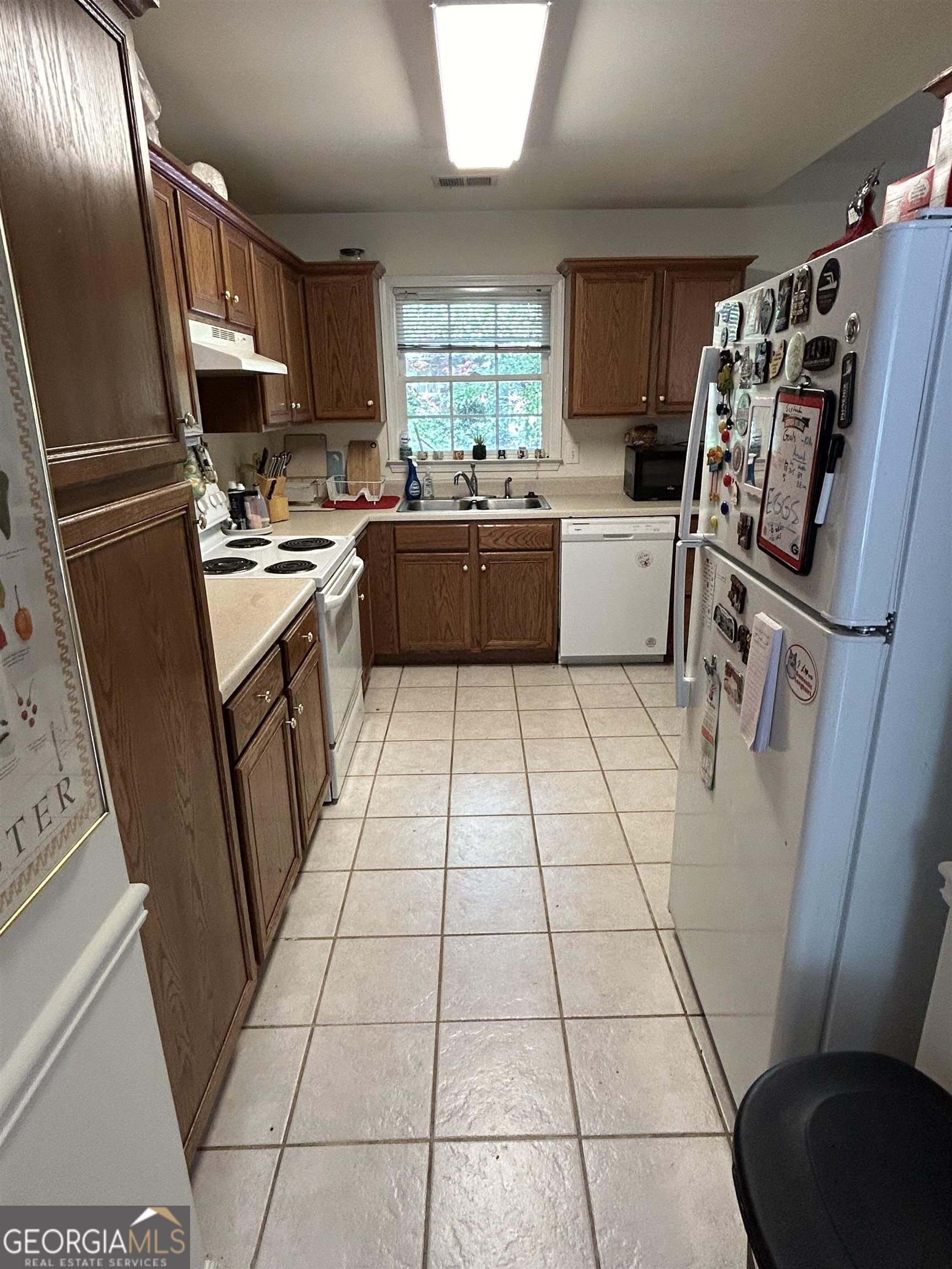 174 Spring Lake Drive Athens, GA 30605 - Photo 7 of 10 a kitchen with granite countertop a refrigerator a sink a stove a washer dryer and a window