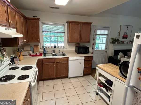 a kitchen with a sink a stove a microwave and cabinets