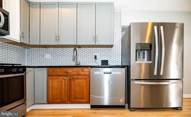 a kitchen with stainless steel appliances granite countertop a refrigerator and a stove