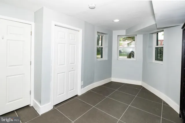 a view of an empty room with closet and a window