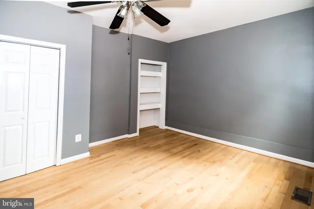 a view of empty room with wooden floor