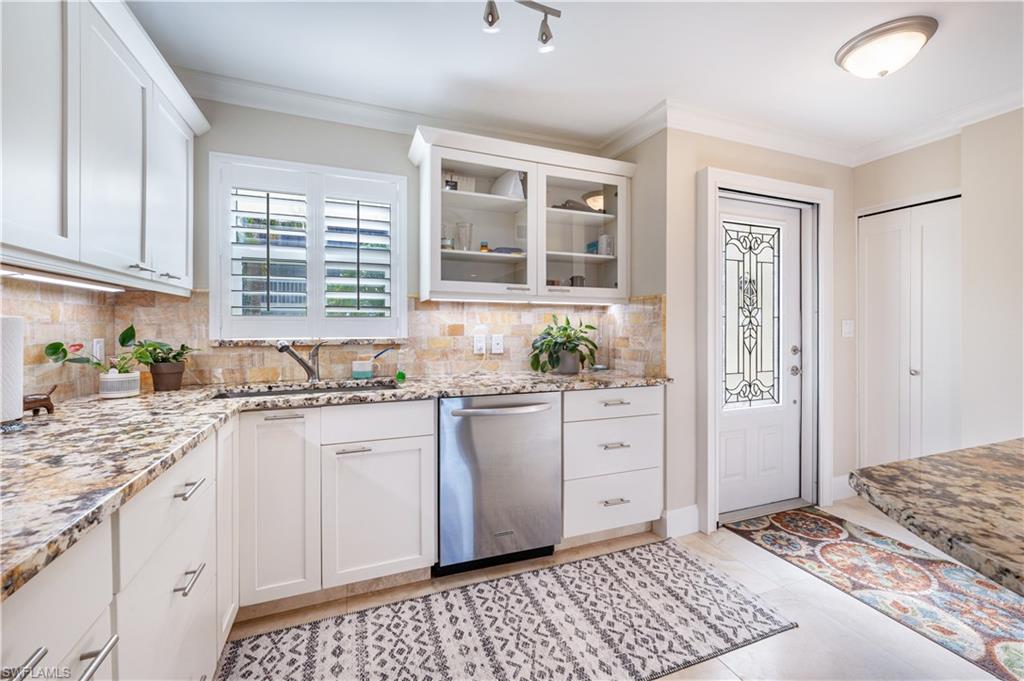 800 River Point Drive, Unit 207 Naples, FL 34102 - Photo 16 of 47 a kitchen with granite countertop a sink stove and cabinets
