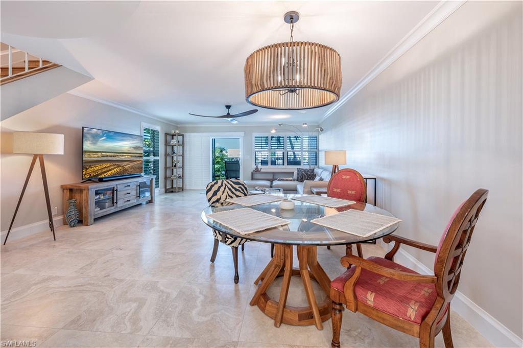 800 River Point Drive, Unit 207 Naples, FL 34102 - Photo 20 of 47 a view of a dining room with furniture a chandelier and wooden floor