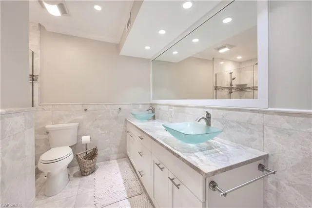a bathroom with a granite countertop sink a toilet and a mirror