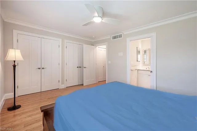 a bedroom with a large bed and a chandelier fan