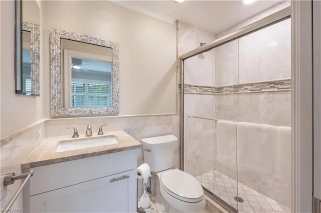 a bathroom with a granite countertop sink mirror vanity and toilet
