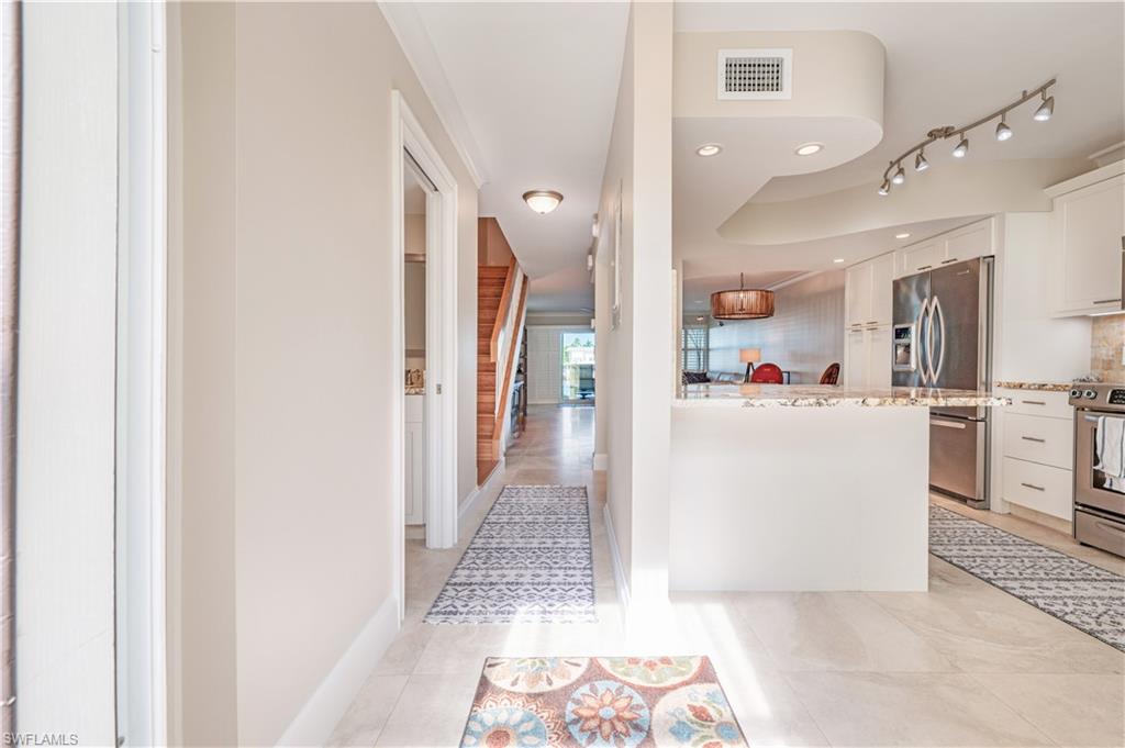 800 River Point Drive, Unit 207 Naples, FL 34102 - Photo 9 of 47 a view of a kitchen with refrigerator and white cabinets
