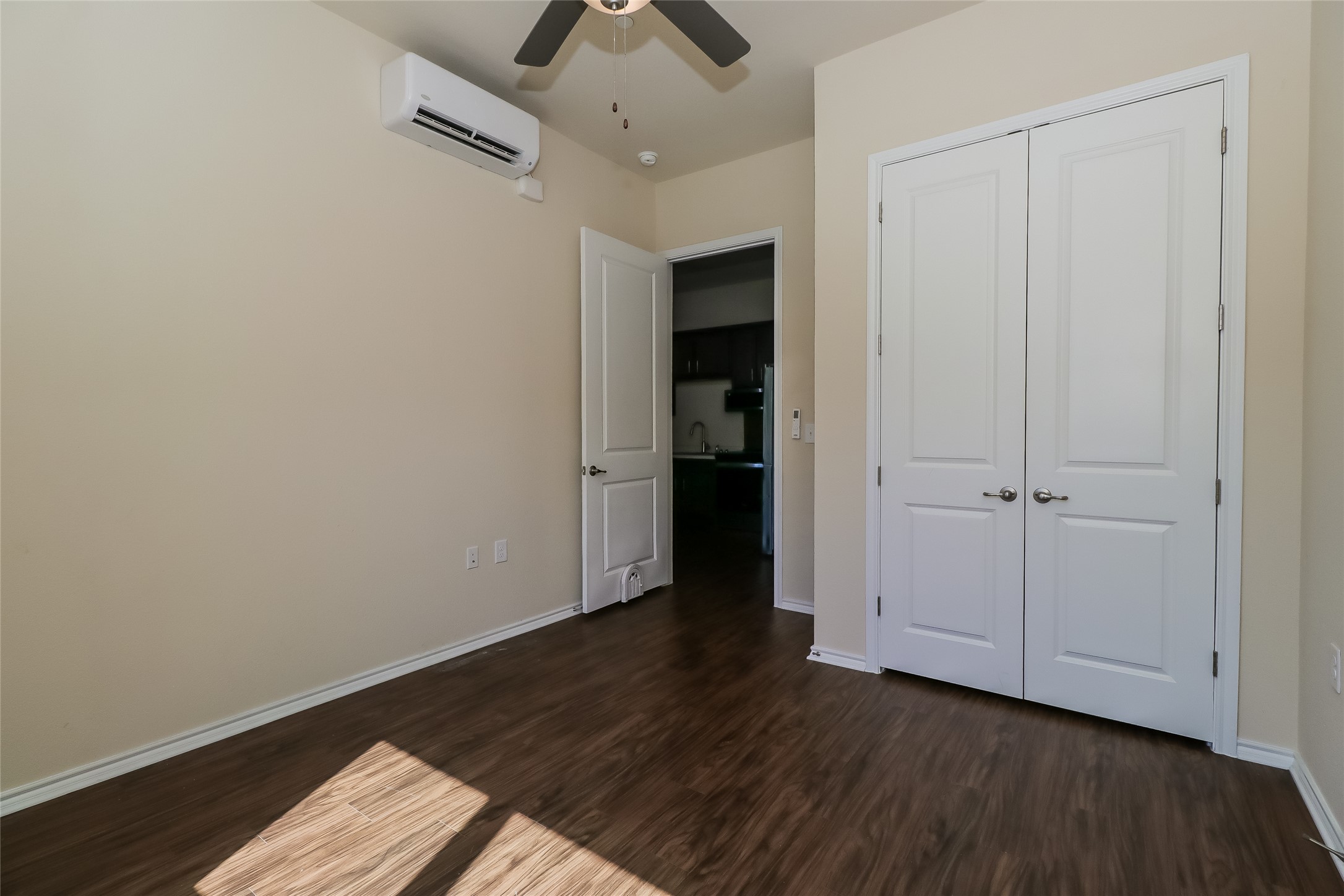 8601 West Gate Boulevard, Unit 7101 Austin, TX 78745 - Photo 11 of 16 Unfurnished bedroom featuring dark wood-style floors, a ceiling fan, and a closet