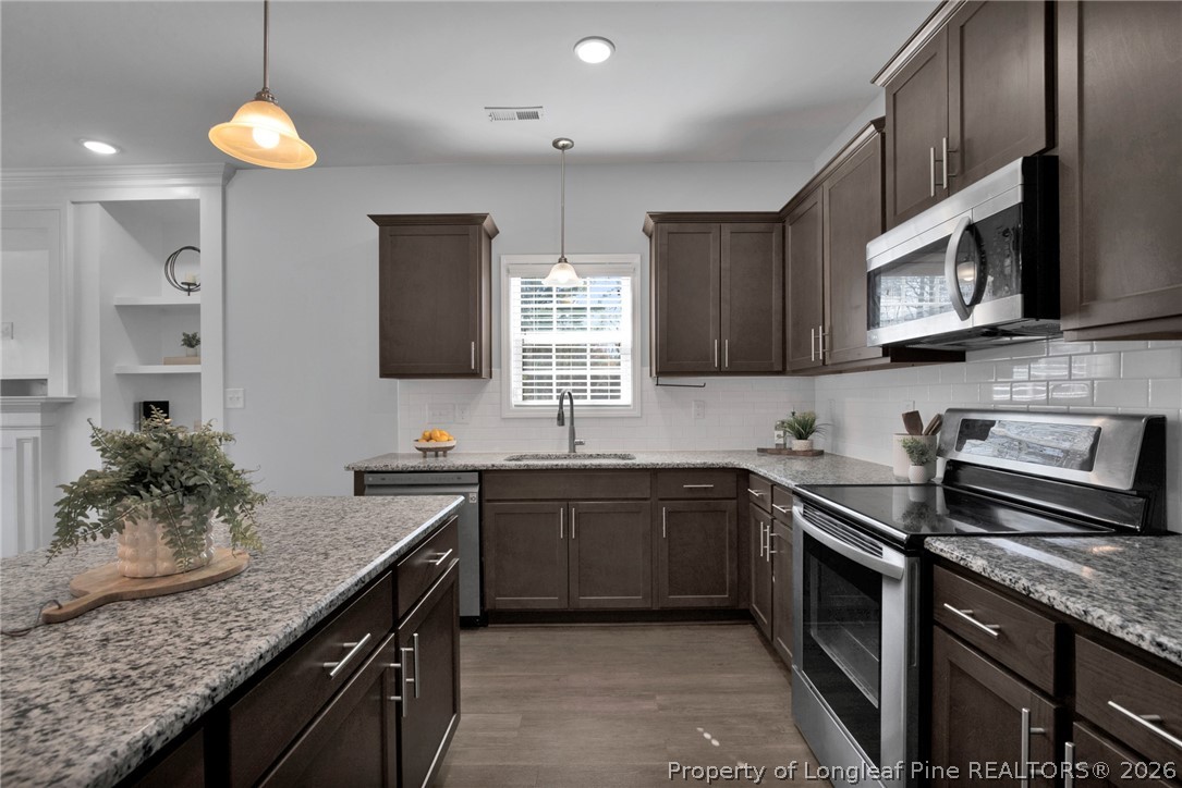 258 Fieldbrook Street Raeford, NC 28376 - Photo 13 of 40 a kitchen with stainless steel appliances granite countertop a sink stove and microwave