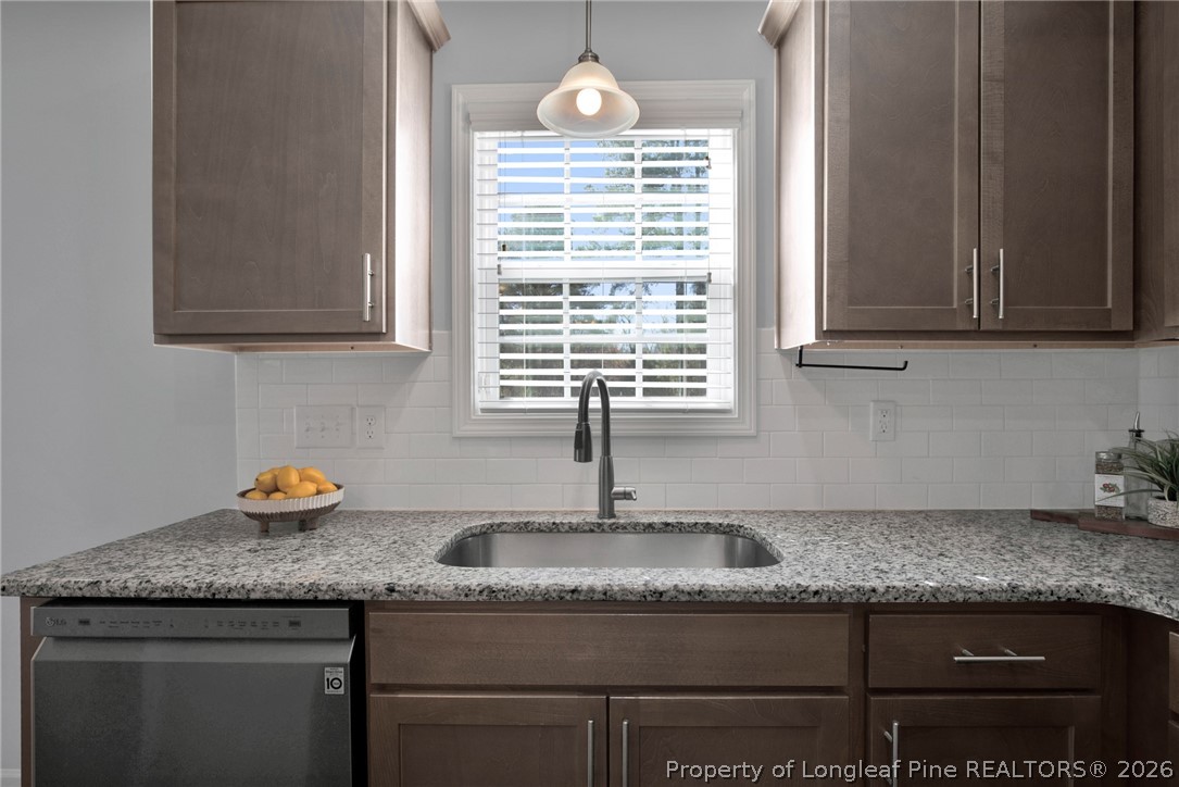 258 Fieldbrook Street Raeford, NC 28376 - Photo 14 of 40 a kitchen with granite countertop a sink a stove and cabinets