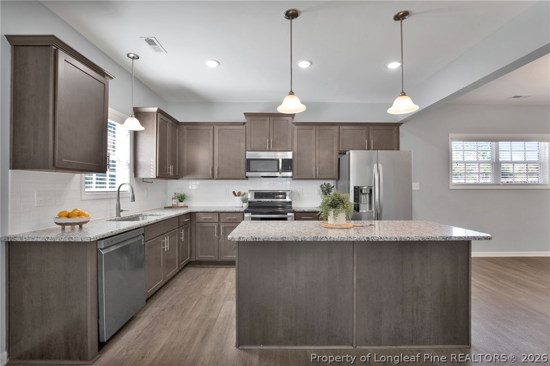 258 Fieldbrook Street Raeford, NC 28376 - Photo 10 of 40 a kitchen with stainless steel appliances granite countertop a refrigerator a sink dishwasher a stove and white countertops with wooden floor