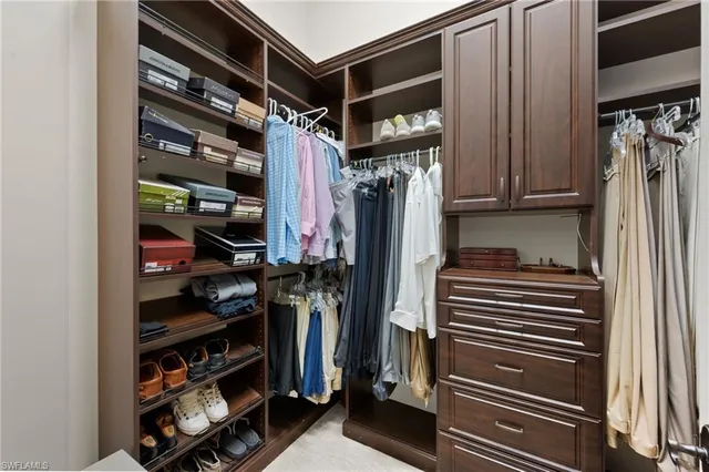 a view of walk in closet with clothes and shoes