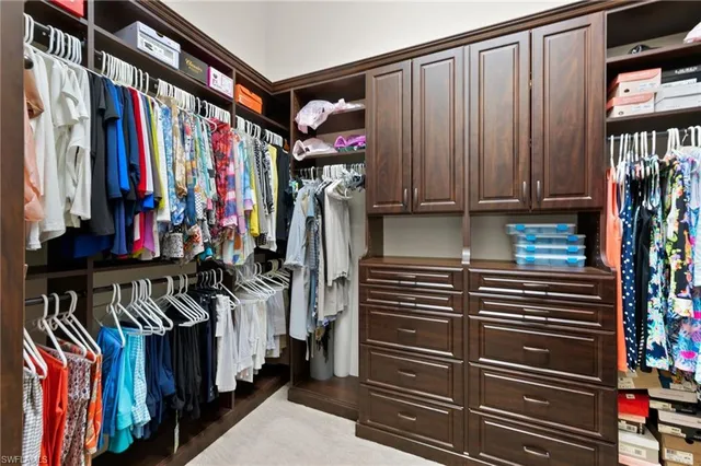 a bedroom with a large bed and a chandelier fan